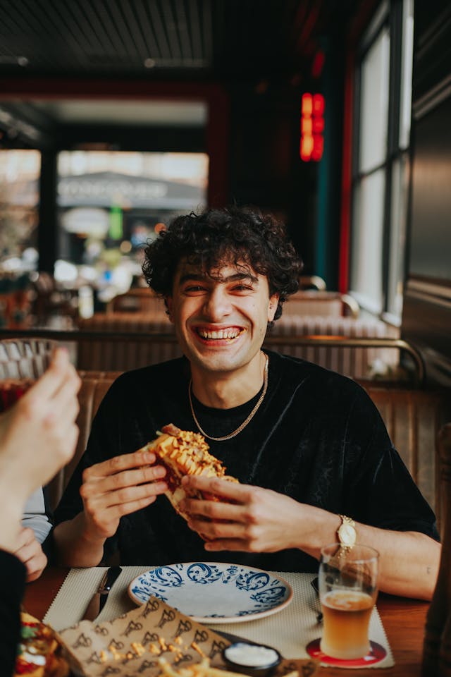 Person smiling while eating at a restaurant