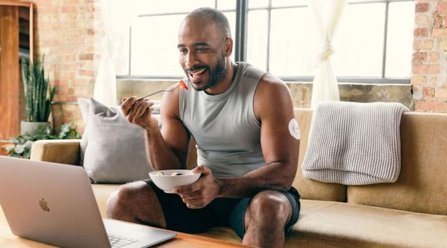 Person eating from a bowl near a laptop after exercise